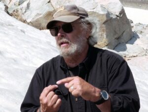 Archeologist Larry Todd demonstrating out in the mountains